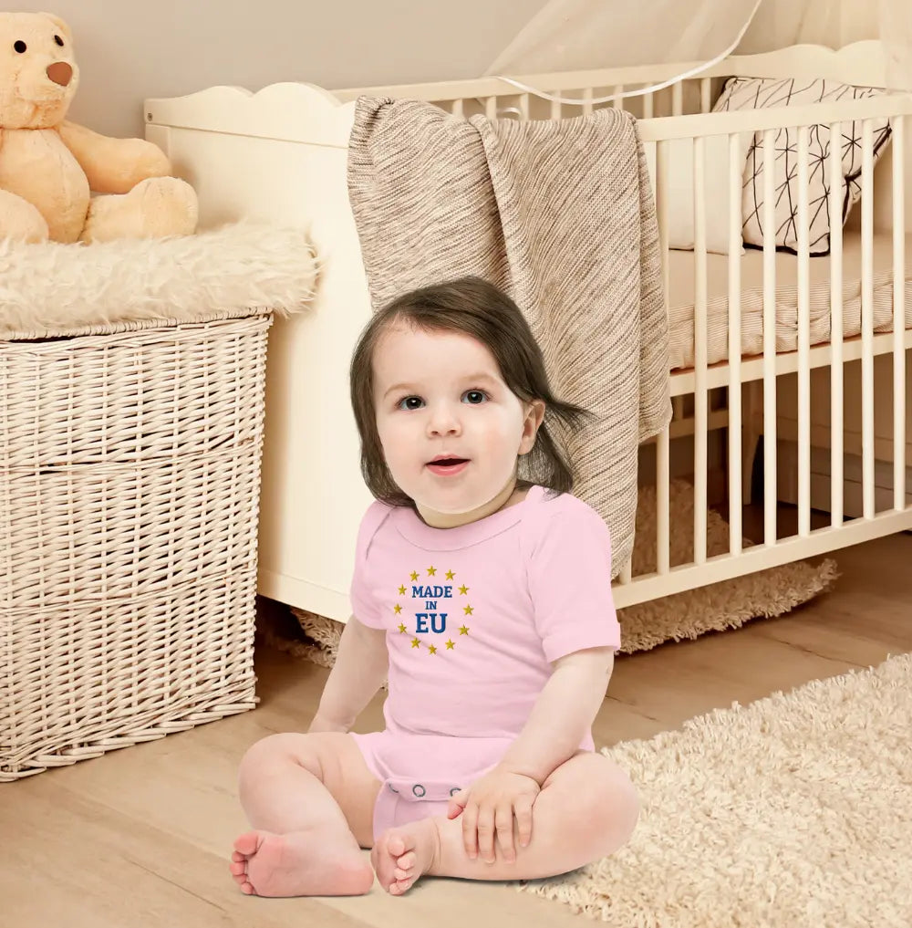 Baby wearing Pink "Made in EU" Onepiece in a Nursery